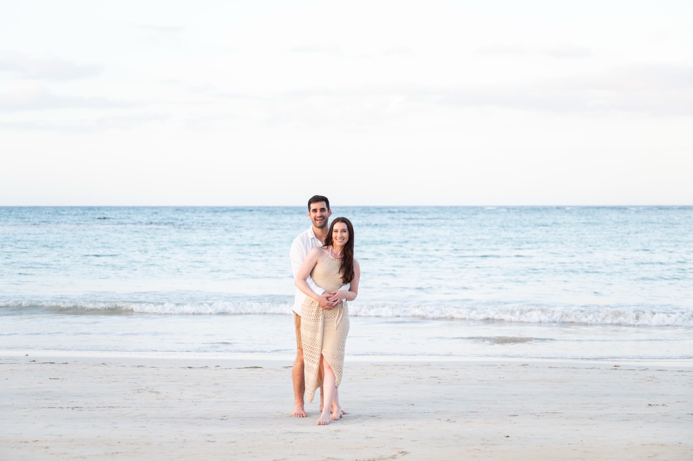 A couple standing together on the shore, full length