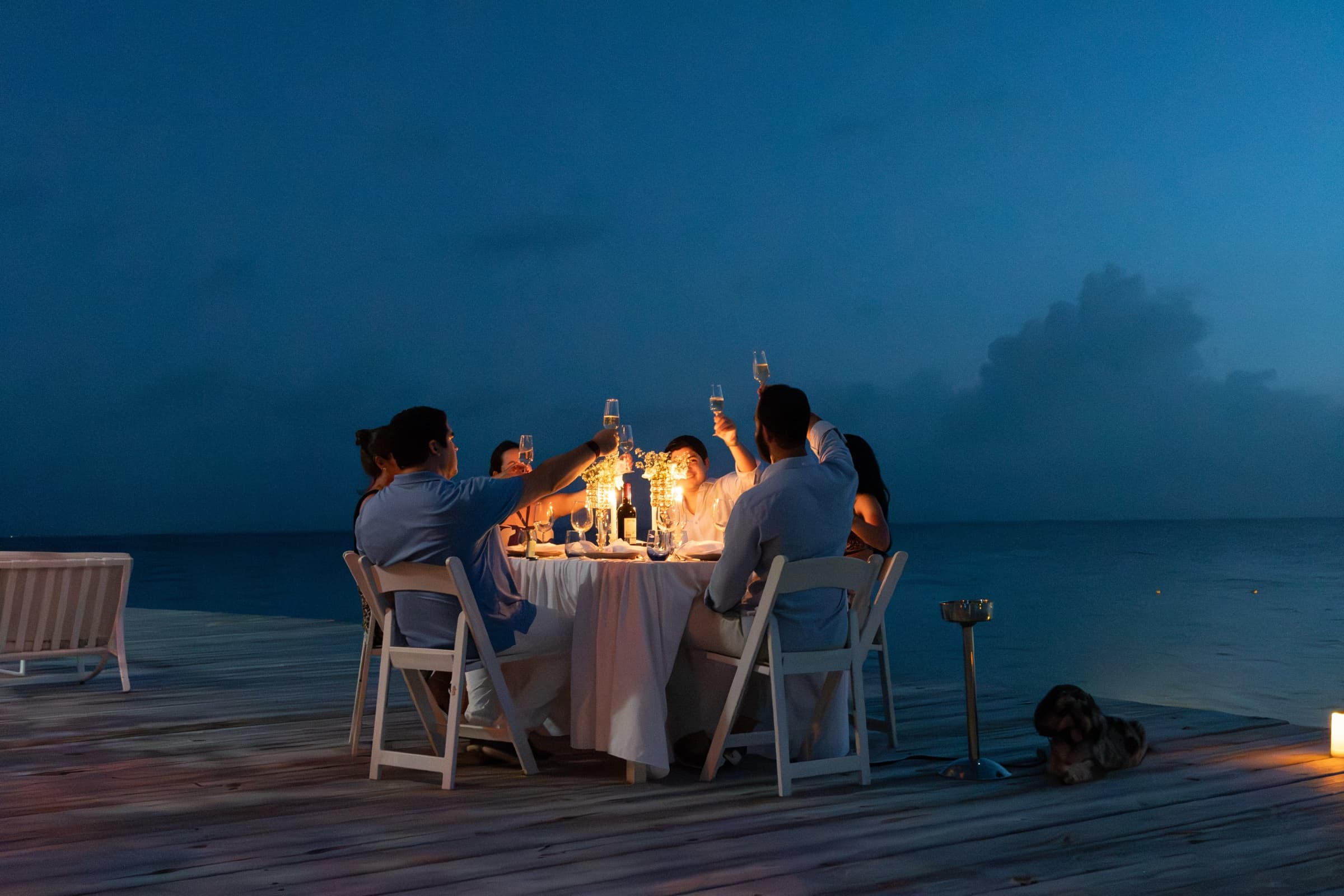 Victor & Carola celebrating with family at an evening dinner over the water