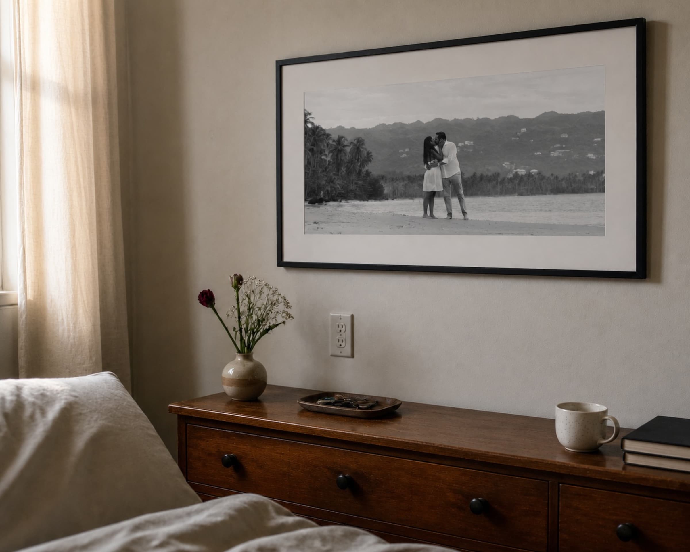 Framed black and white beach portrait above a bedroom dresser