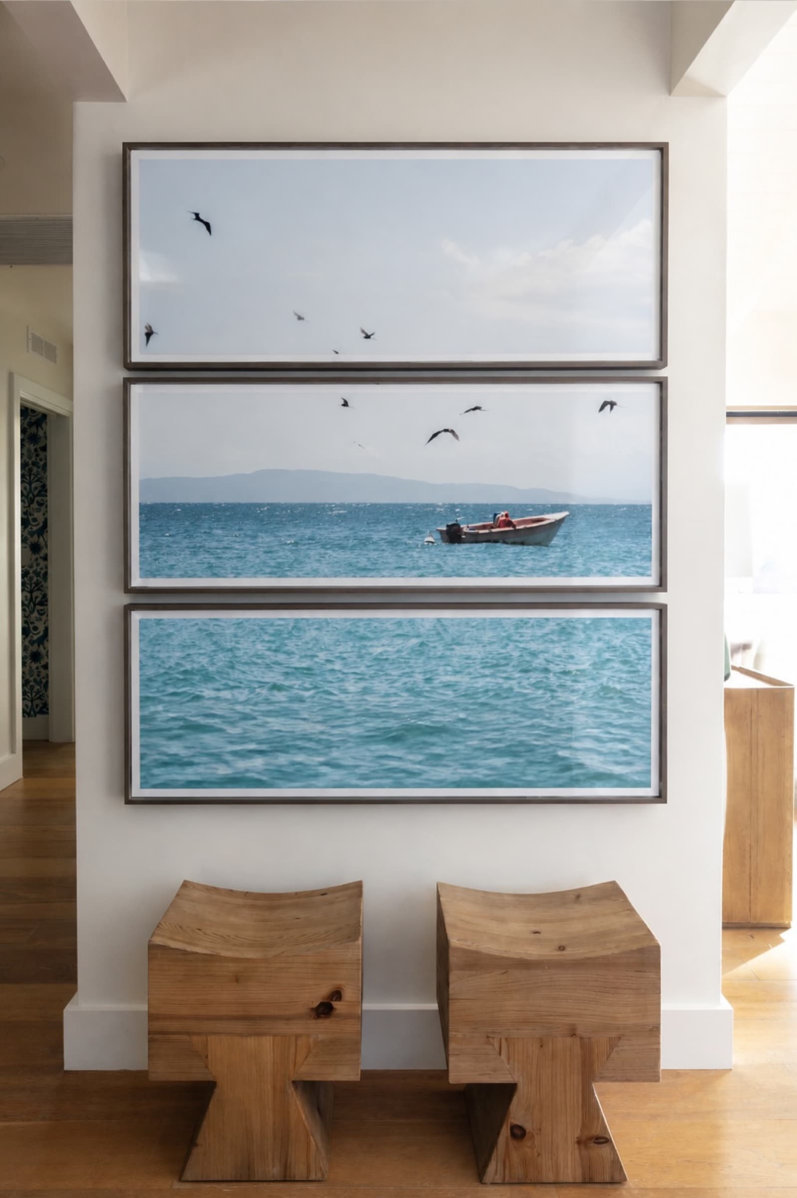 A three-piece framed triptych of birds, a fishing boat, and open water